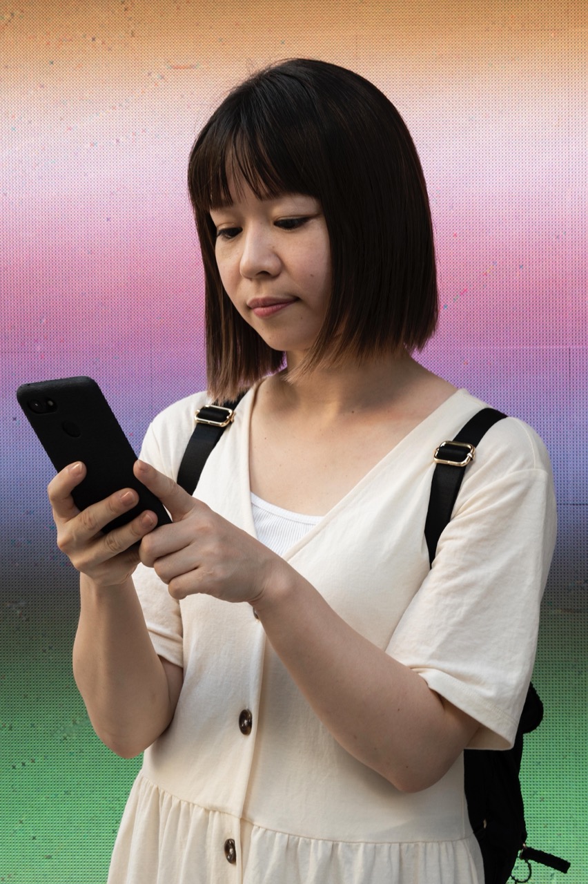 young-asian-woman-checking-her-phone-outdoors lớn.jpeg