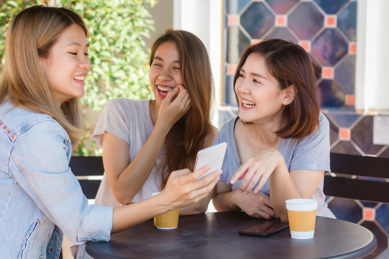 cheerful-asian-young-women-sitting-cafe-drinking-coffee-with-friends-talking-together lớn.jpeg