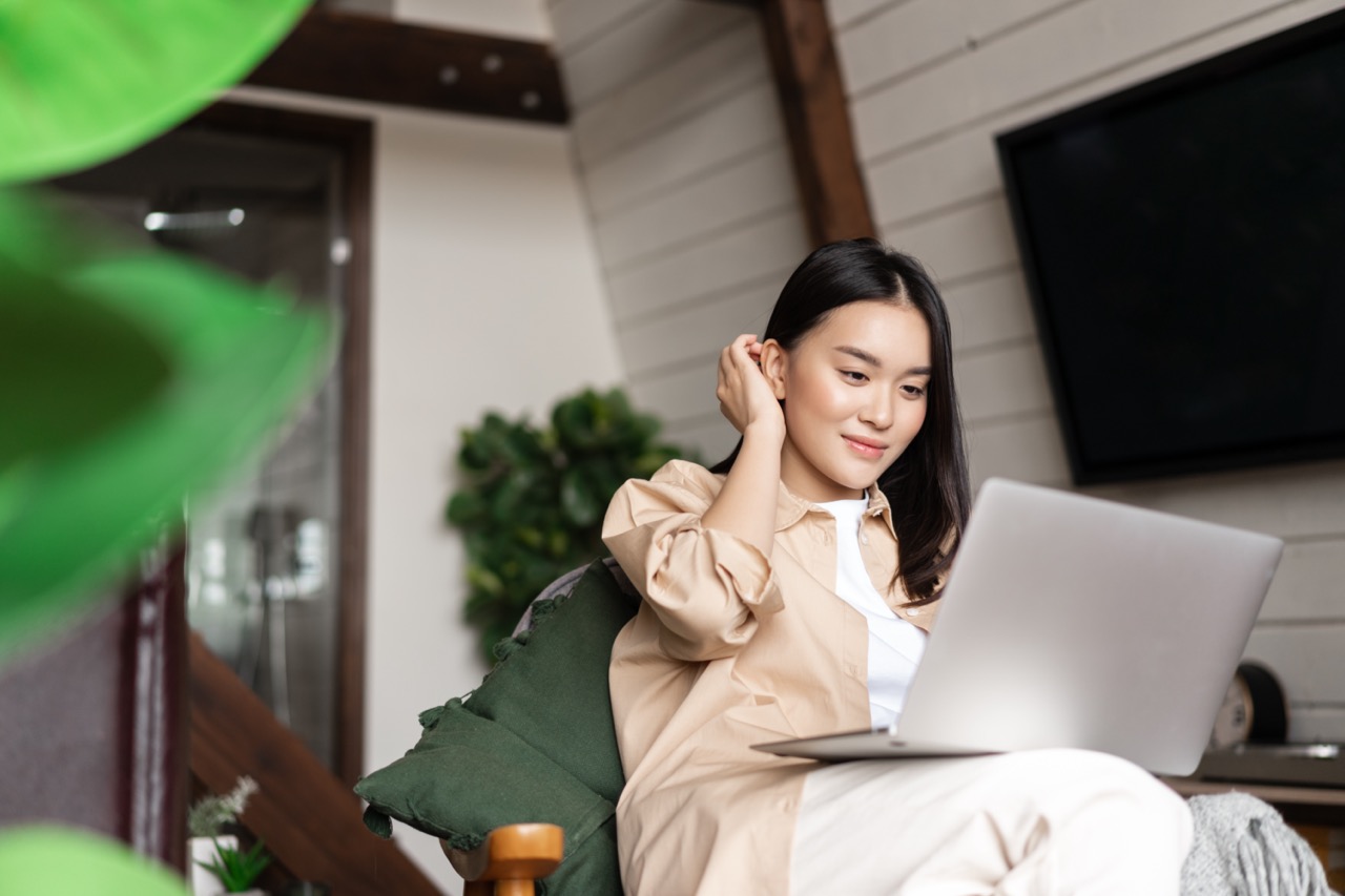 young-asian-woman-sitting-home-with-laptop-computer-girl-browsing-websites-studying-remotely lớn.jpeg